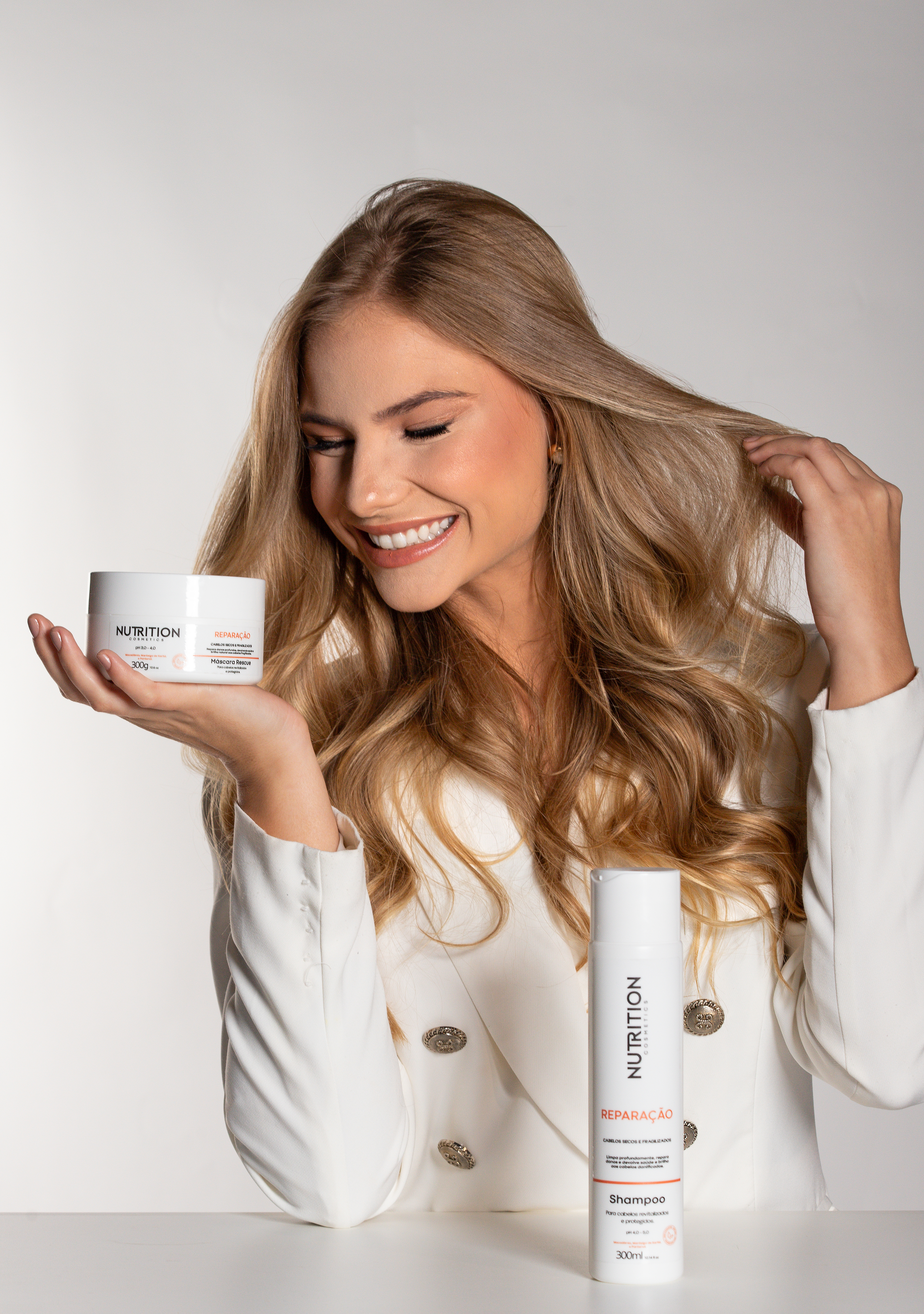 Modelo segurando Kit Reparação Nutrition Cosmetics